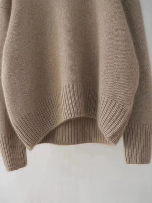 Cozy beige acrylic knit sweater with dropped shoulders and ribbed cuffs and hem.