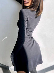 Black ribbed knit mini dress with long sleeves and a tie waist detail.