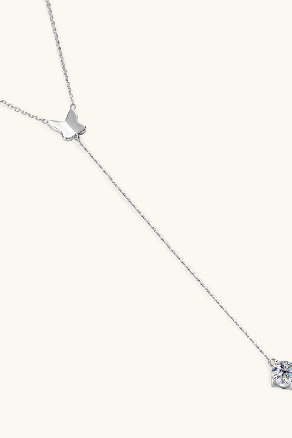 Silver lariat necklace with butterfly charm and moissanite pendant.