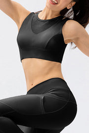 Black mesh inset performance bra top with V-neck detail and athletic cut.