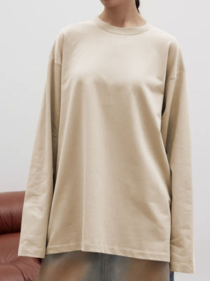 Oversized tan crewneck sweatshirt with voluminous long sleeves and ribbed neckline.