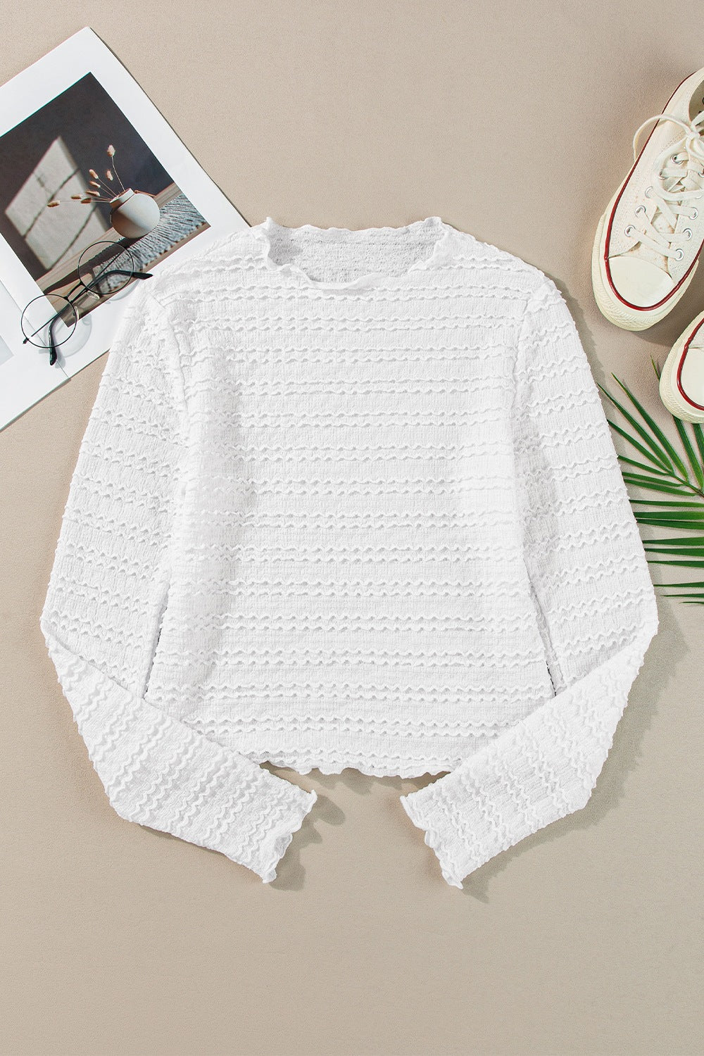 White textured long sleeve top with ruffle trim and a crew neck.
