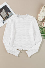 White textured long sleeve top with ruffle trim and a crew neck.