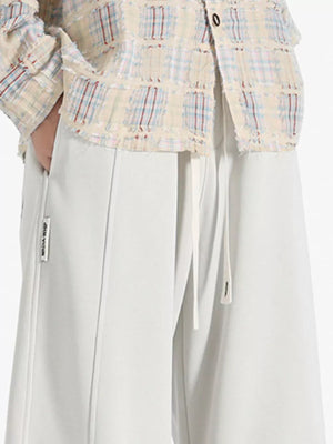 Casual wide-leg sweatpants in ivory with drawstring and front seam detail.