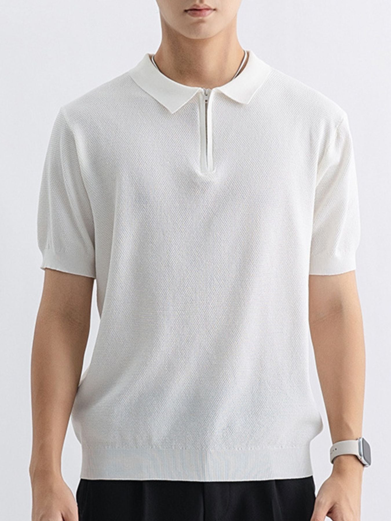 White textured knit zip-up polo shirt with short sleeves and a spread collar.