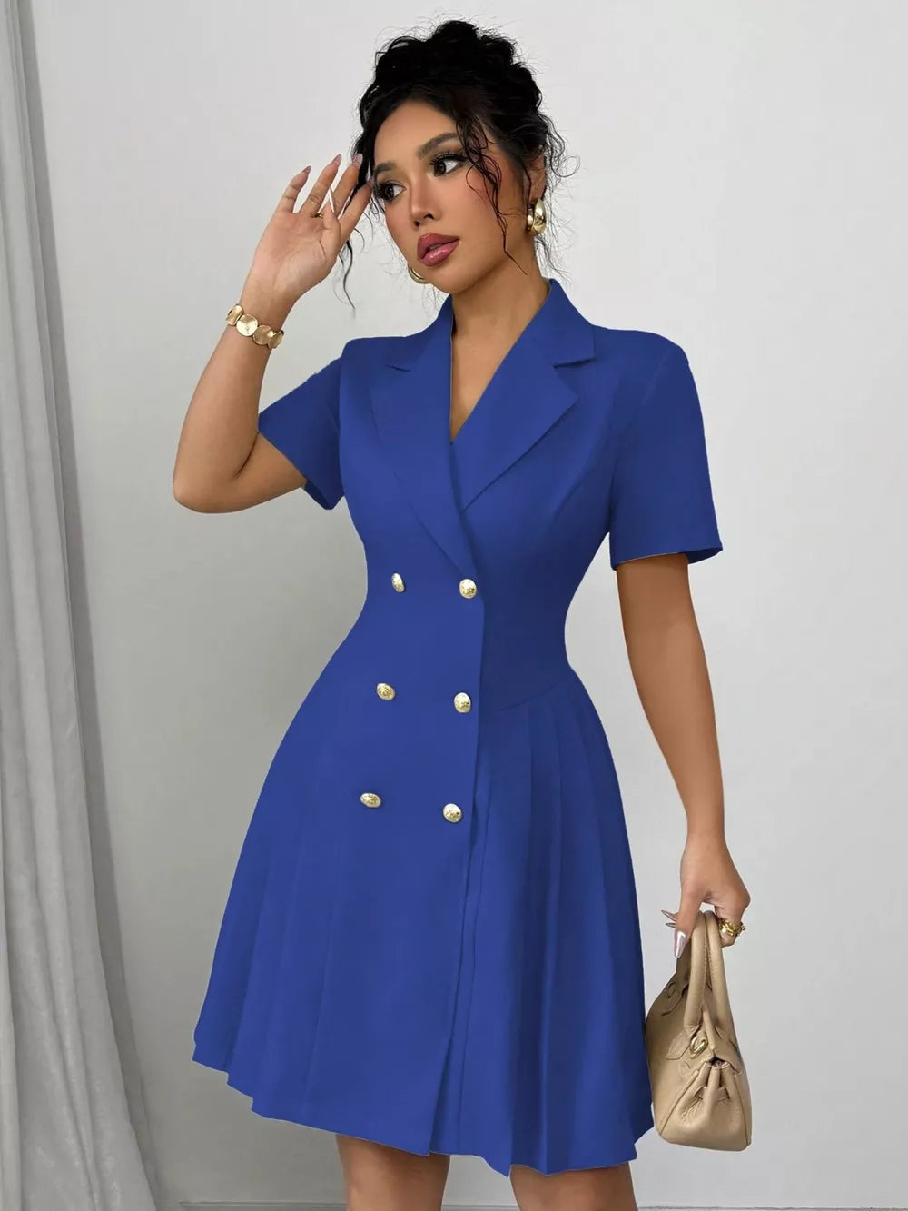 Blue double-breasted pleated blazer dress with gold buttons and short sleeves.