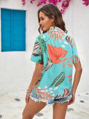 Tropical print camp collar shirt in aqua with short sleeves and a buttoned front, styled with denim shorts.