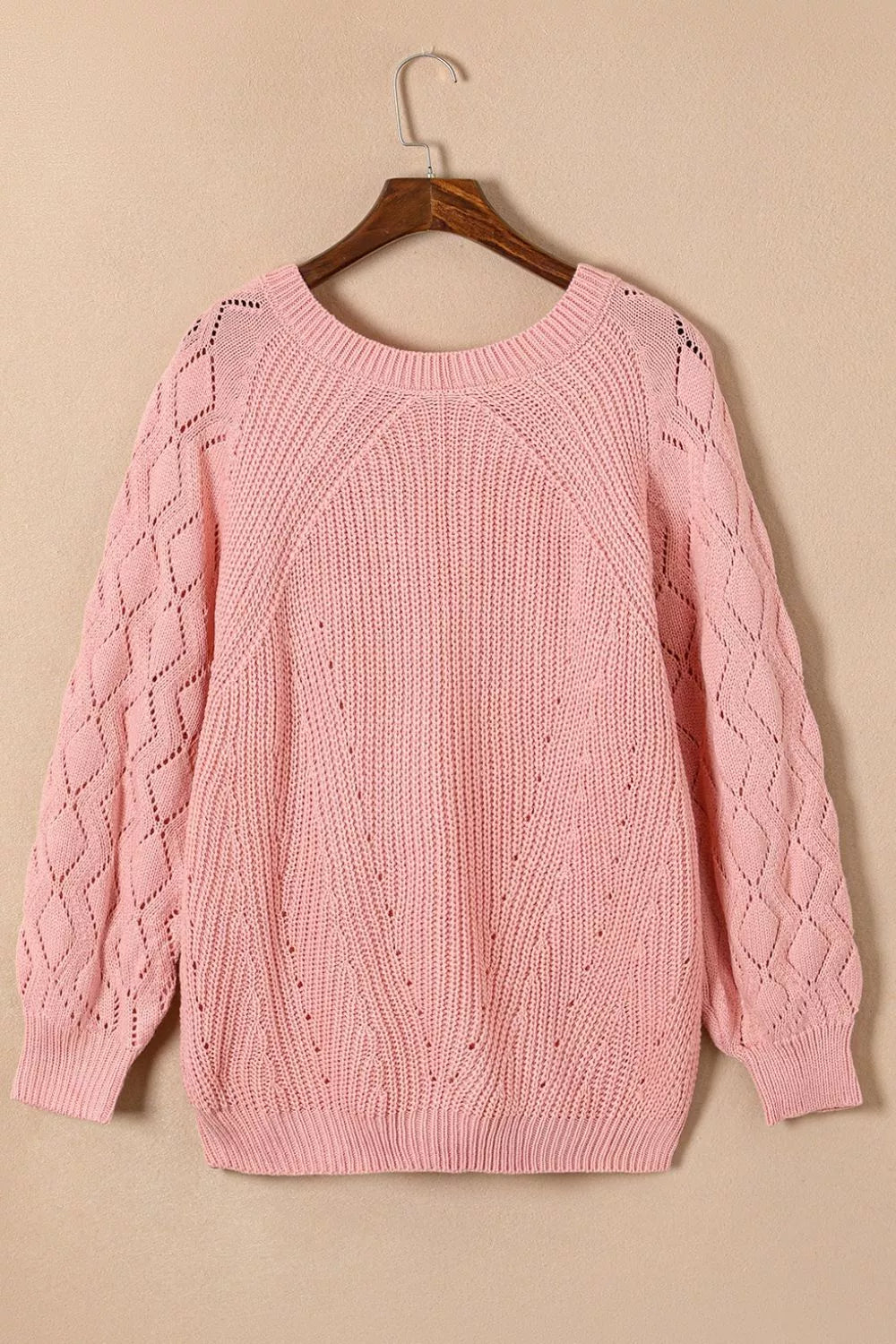 Dusty pink hollow-out knit sweater with puffy sleeves and diamond pattern detail.