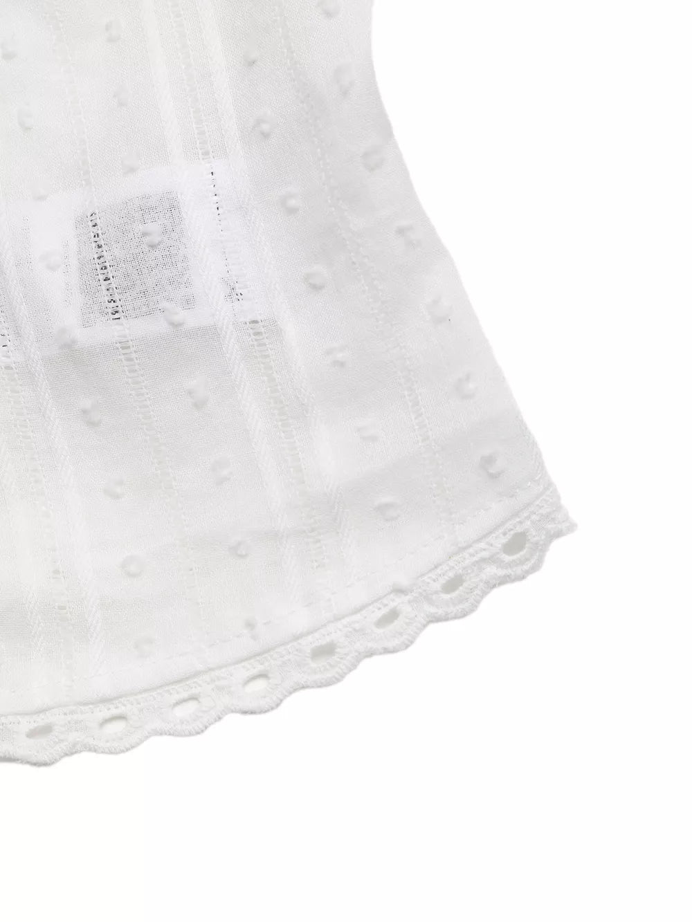 White sleeveless maternity blouse with dobby dots, vertical stripes, and lace trim hem.
