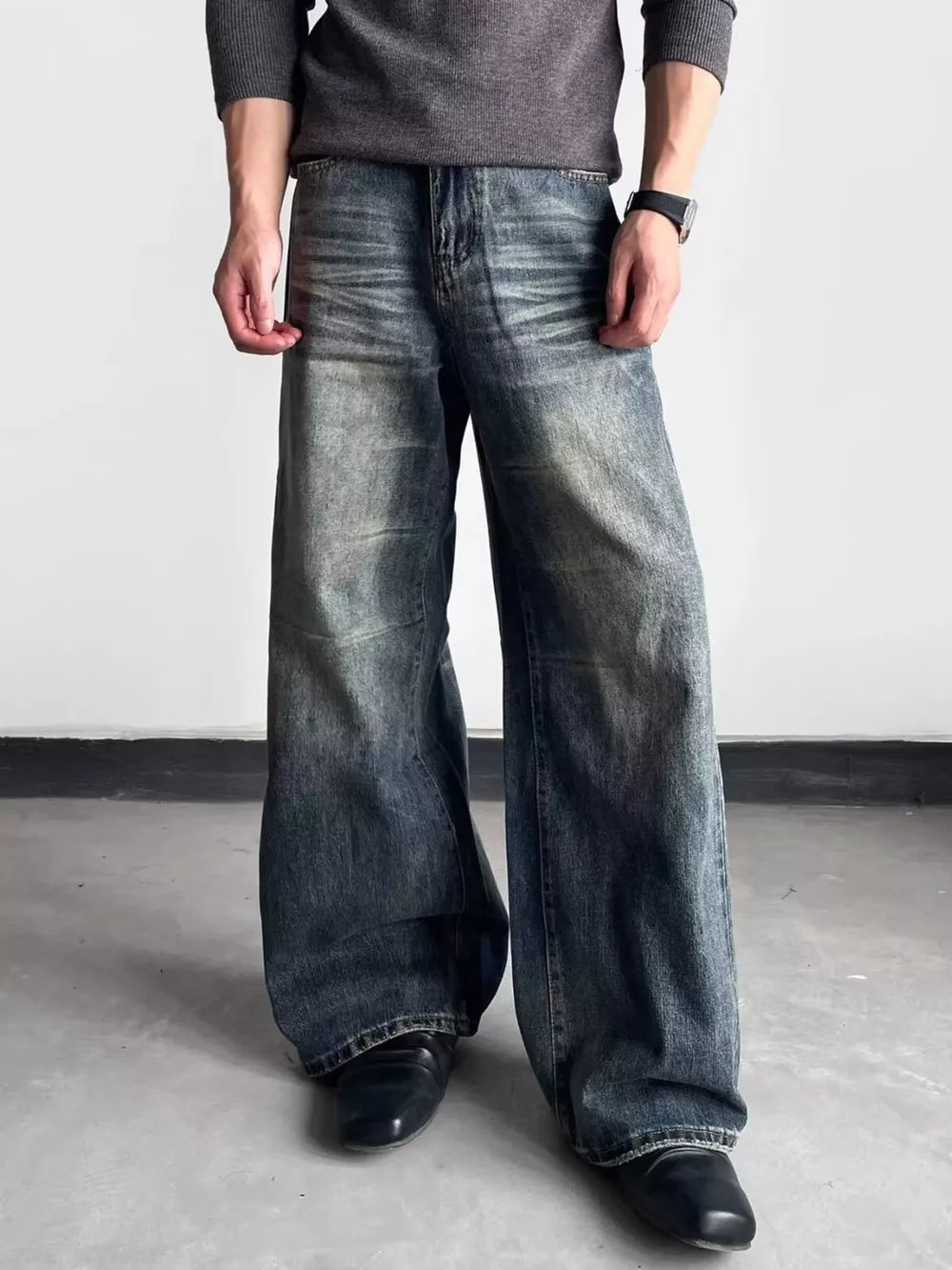 Men's blue distressed wide-leg denim jeans with a relaxed fit.