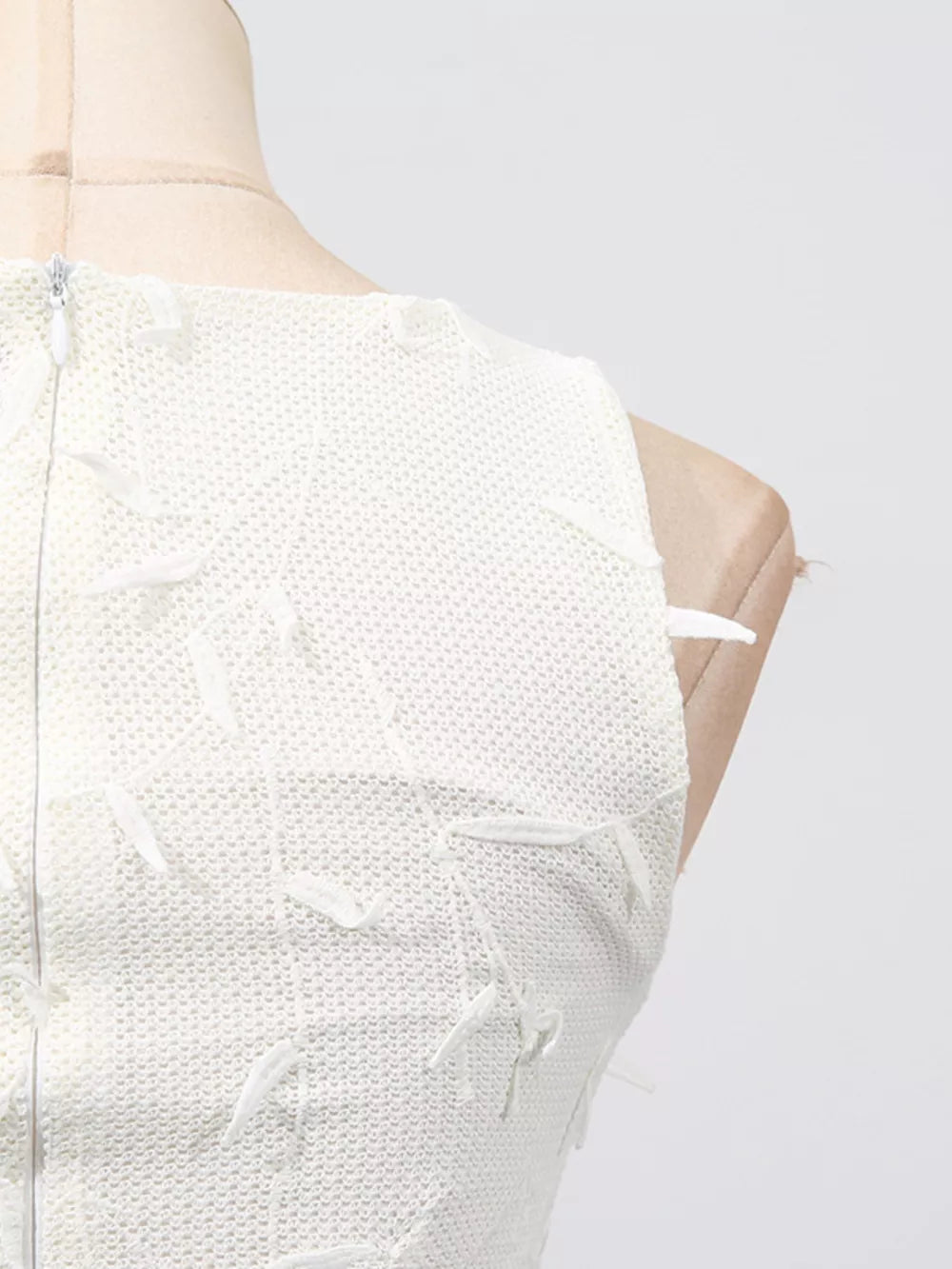 White midi dress with floral applique and boat neck, showing back zipper detail.