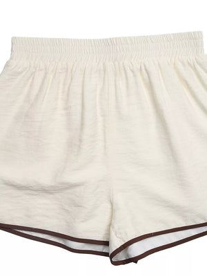 Beige shorts with elastic waistband and brown trim detail