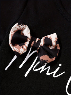 Black baby tee with leopard print bow accent and white script text