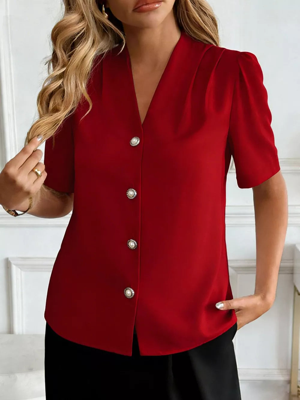 Burgundy V-neck short sleeve shirt with pearl button details and puff sleeves.