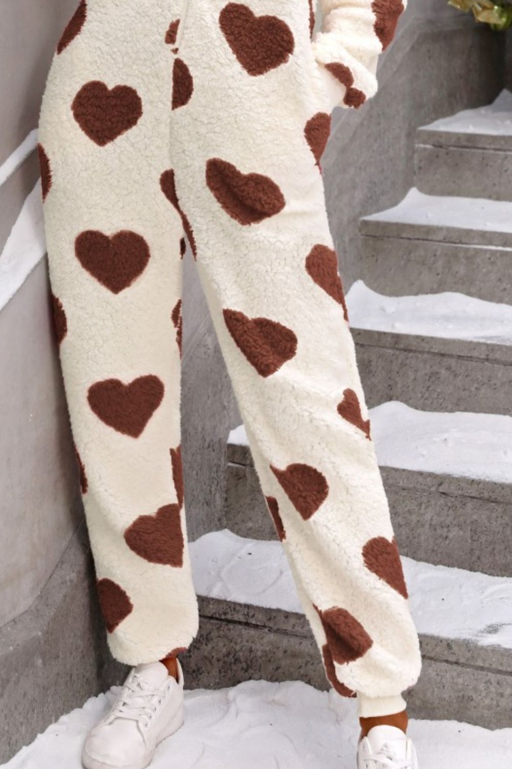 Cream sherpa onesie pants with brown heart print and cuffed ankles.
