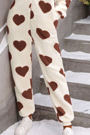 Cream sherpa onesie pants with brown heart print and cuffed ankles.