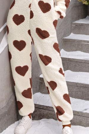 Cream sherpa onesie pants with brown heart print and cuffed ankles.