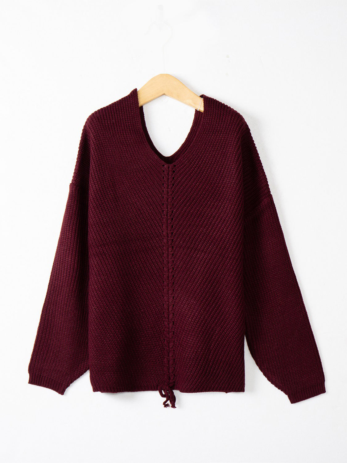 Burgundy knit sweater with V-neck, long sleeves, and adjustable drawstring hem detail.