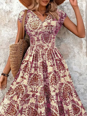 Maxi dress with smocked bodice, V-neck, short sleeves, and tiered skirt in a damask pattern.