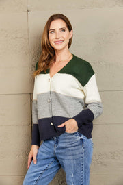Colorblock acrylic cardigan with metallic trim in green, white, grey, and navy.