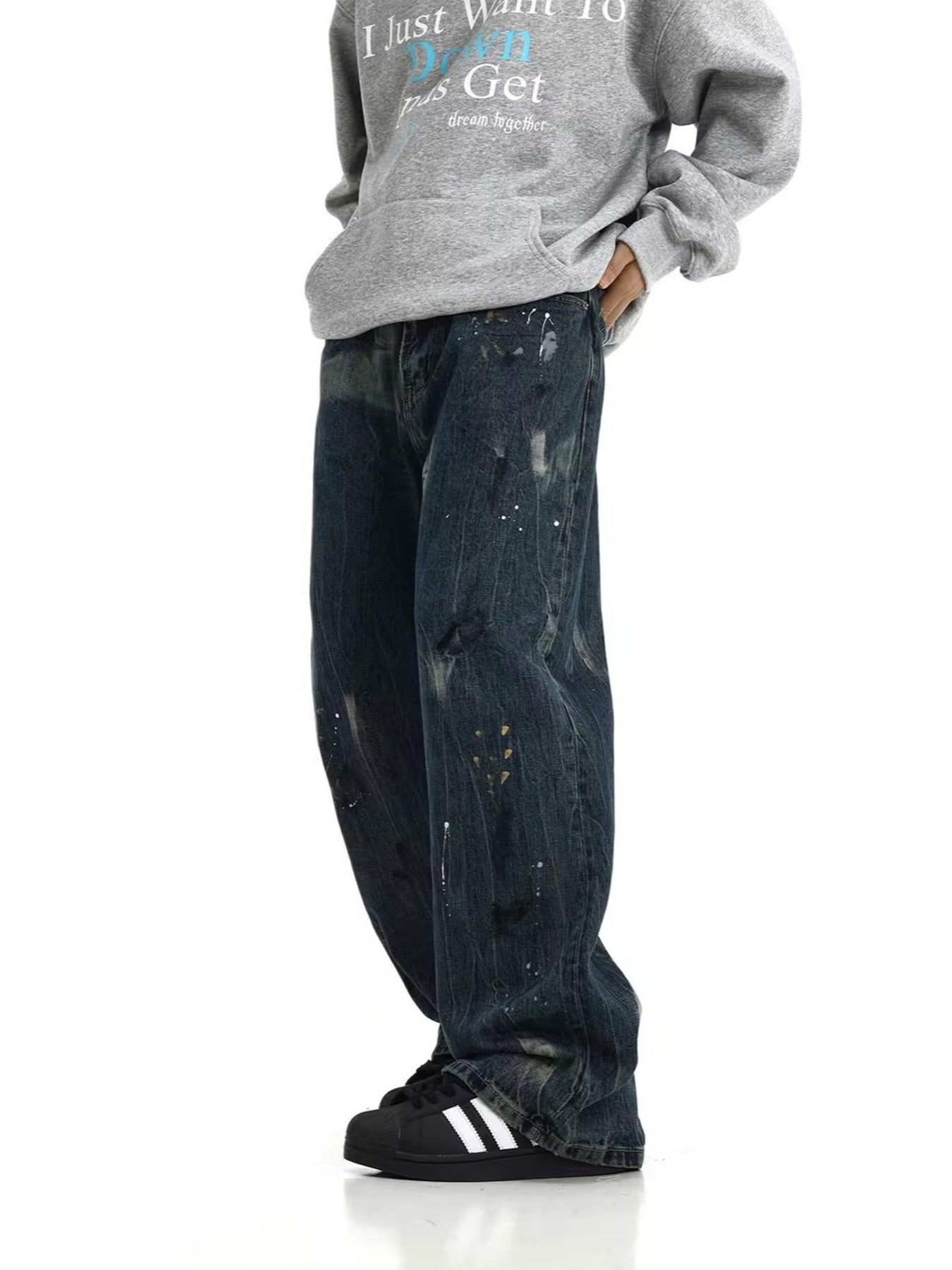Distressed dark blue wide-leg cotton jeans with paint splatters and rips.