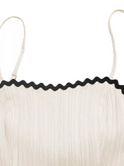 Cream cami dress with black scalloped contrast trim and textured fabric.