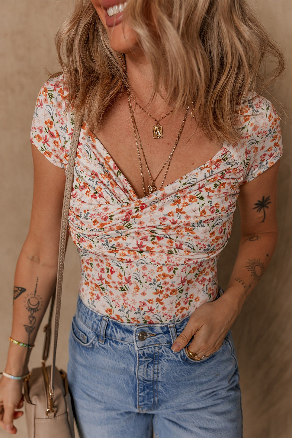 Floral print ruched bodysuit with sweetheart neckline and short sleeves.
