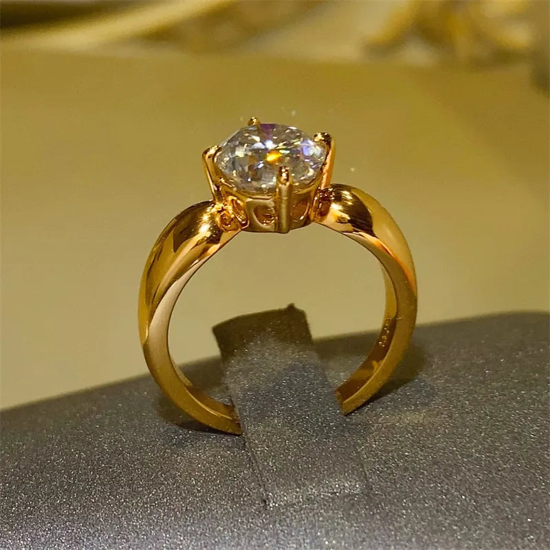 Gold moissanite solitaire ring with oval cut stone on a polished band.