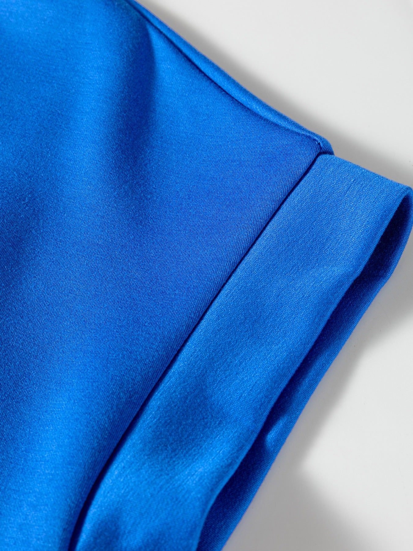 Vibrant blue polo shirt detail showing collar and cuff seam.
