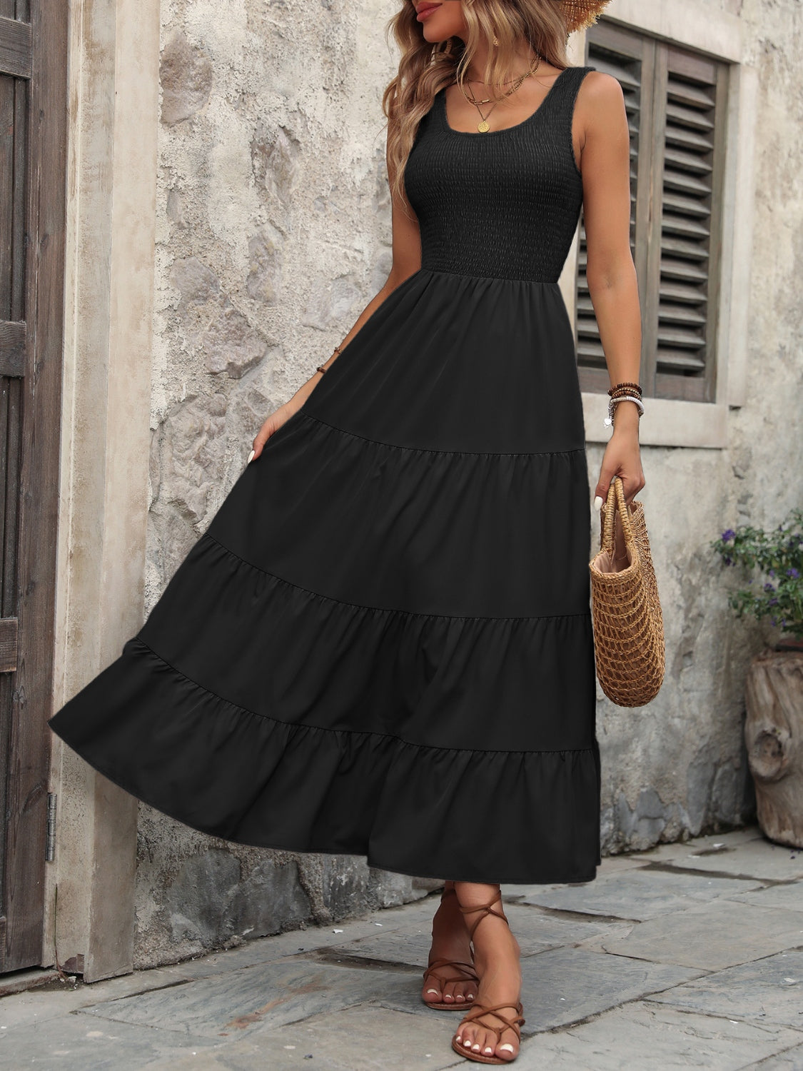 Black smocked bodice tiered maxi dress with scoop neck and sleeveless design.