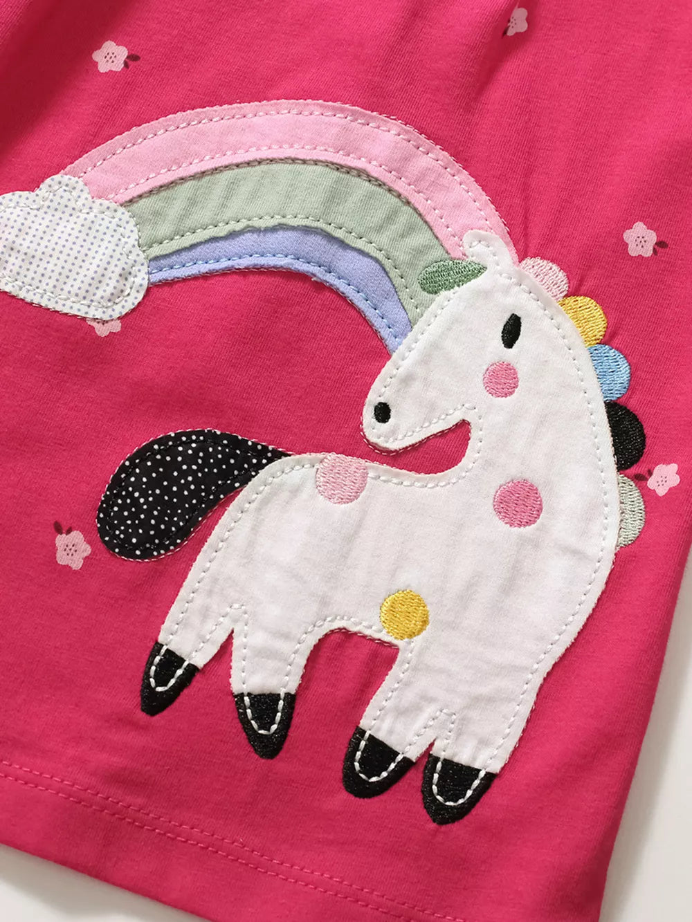 Toddler dress with embroidered unicorn and rainbow applique on pink cotton fabric.