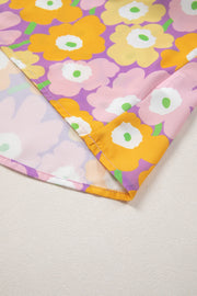 Puff sleeve blouse with ruffle trim in a floral print with purple, pink, yellow, and orange flowers.