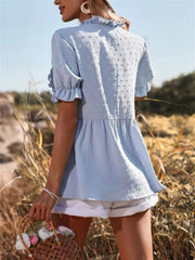 Light blue textured peplum blouse with ruffle trim and short sleeves.