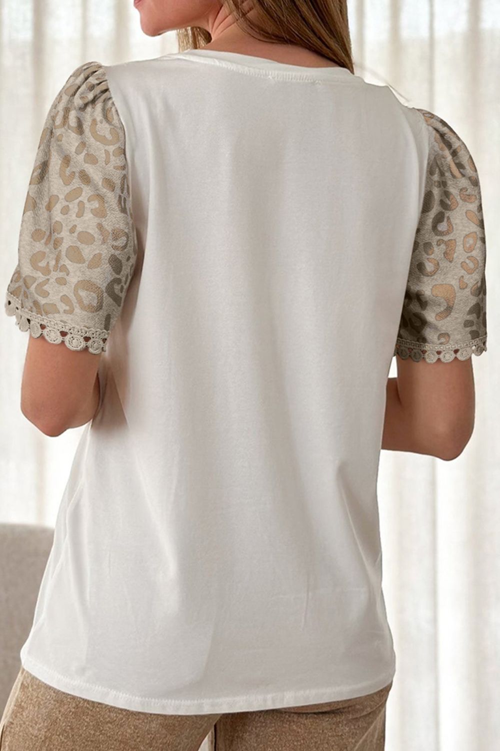 White cotton t-shirt with leopard print puff sleeves and crochet trim.