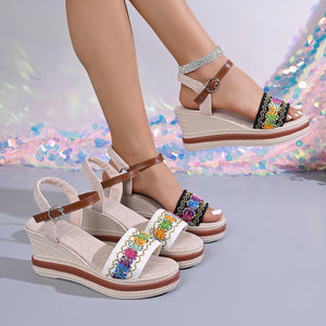 Embroidered floral wedge sandals in gray/white and black with adjustable straps and a comfortable wedge heel.