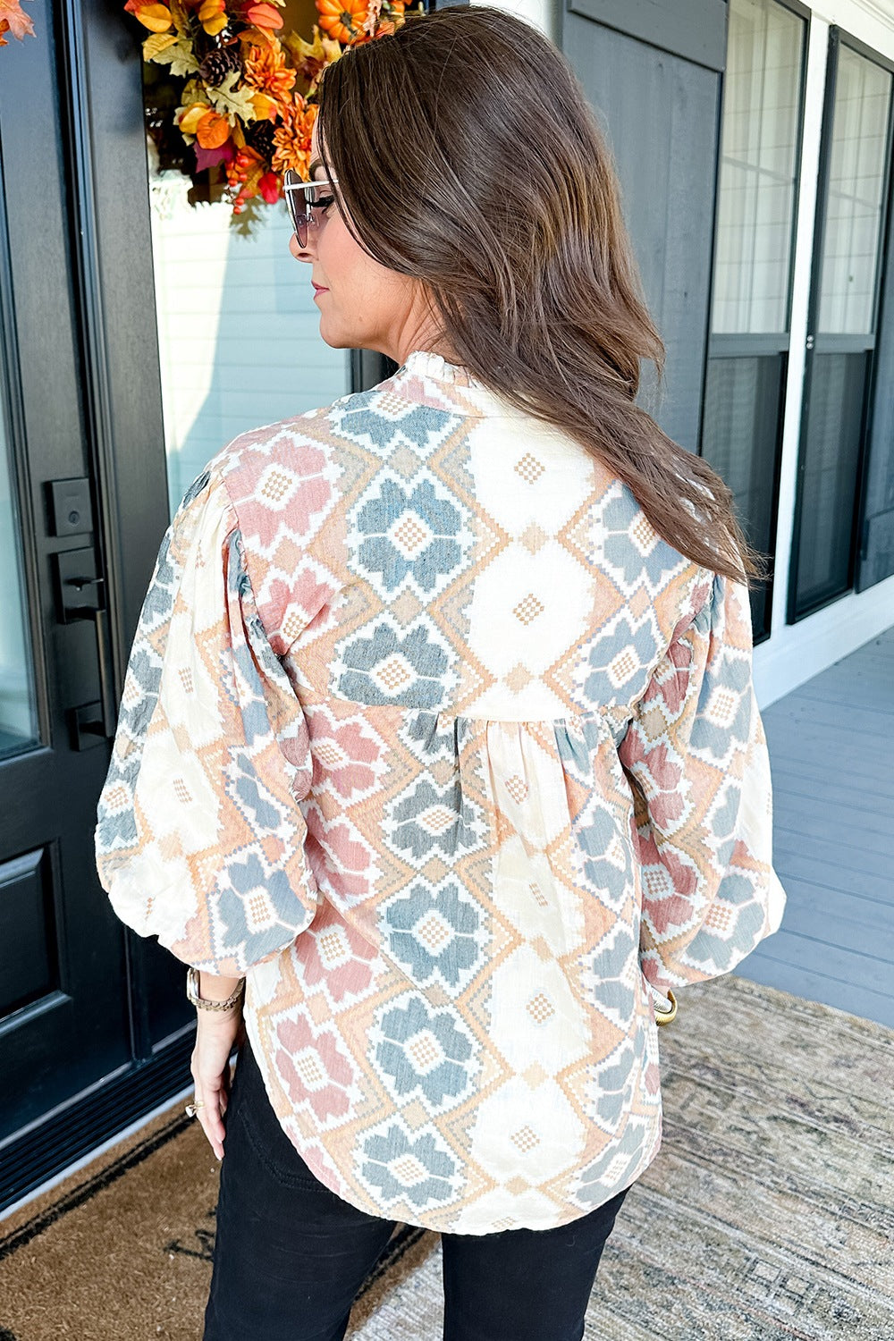 Geometric print blouse with tassel tie in floral colors, featuring balloon sleeves.