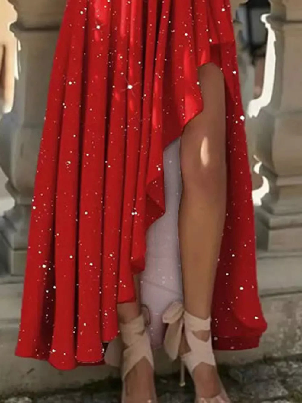 Deep red glitter maxi dress with asymmetrical hem and thigh slit.