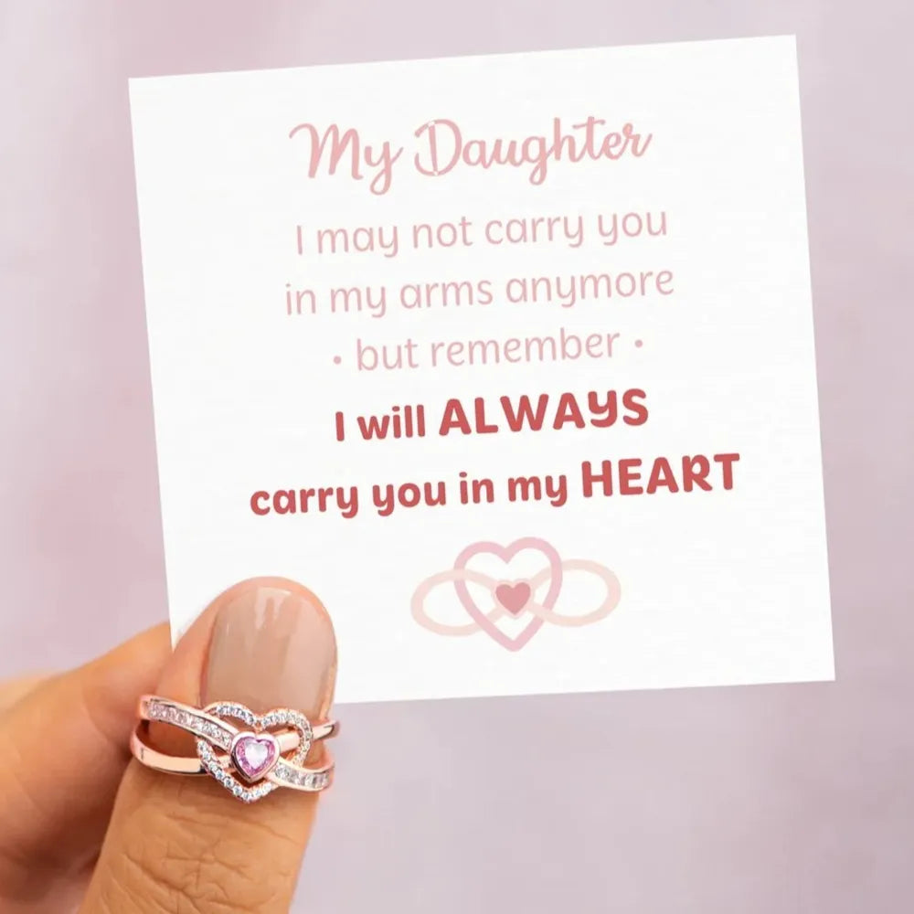 Rose gold ring with intertwined hearts and cubic zirconia detail.