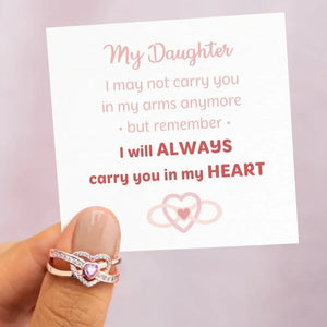 Rose gold ring with intertwined hearts and cubic zirconia detail.