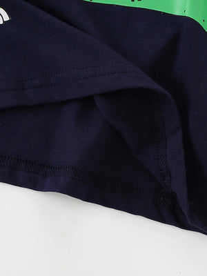 Children's navy t-shirt with a green dinosaur graphic detail and visible stitching.