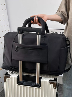 Black Oxford rolling travel organizer bag with telescoping handle and front zip pocket.