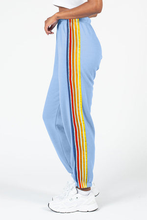 Light blue track pants with rainbow stripe detail on the side.