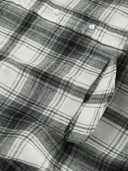 Button-up long sleeve cotton shirt in black and white plaid with a chest pocket.