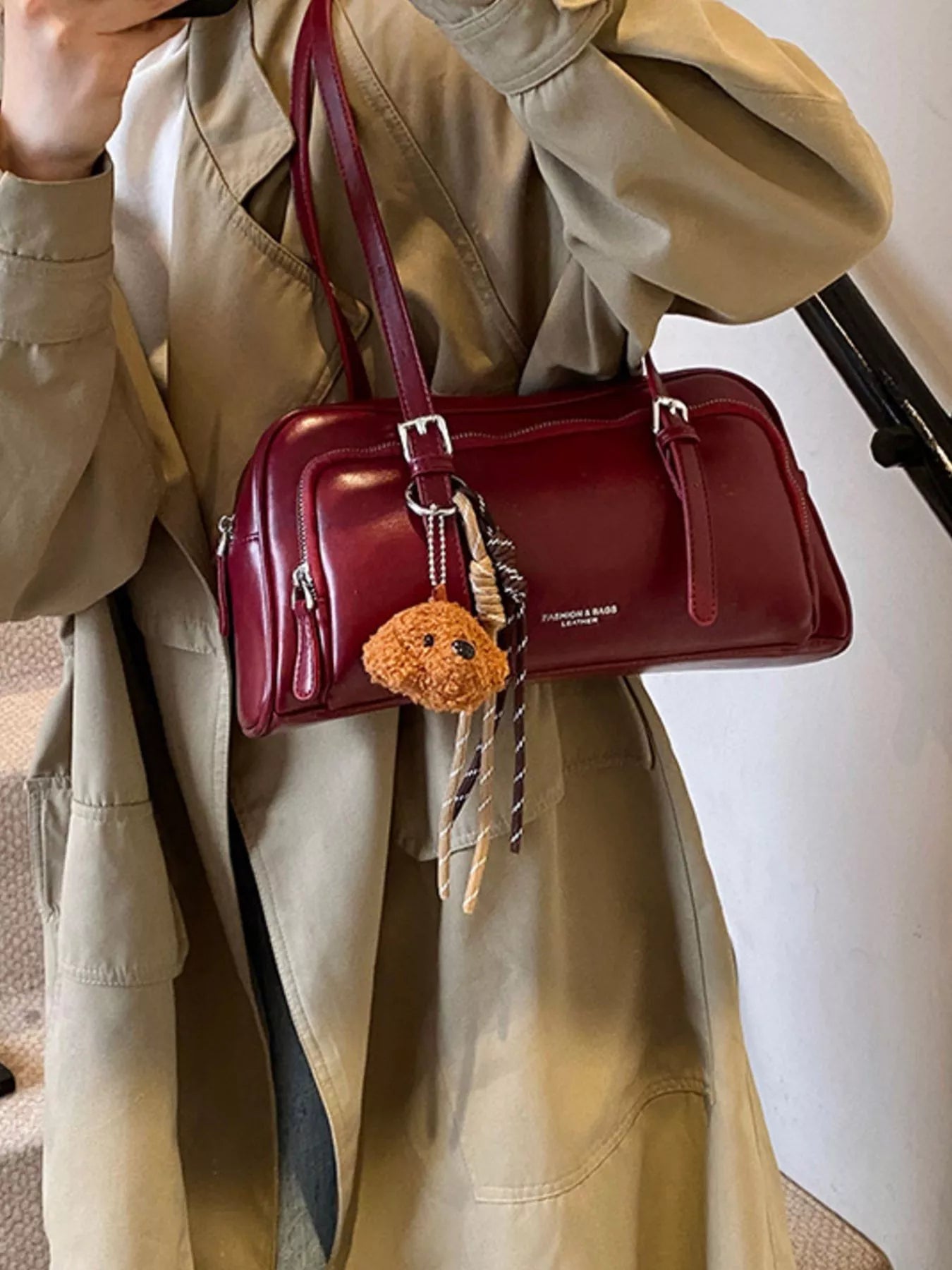 Deep red vintage leather shoulder bag with charm and fringe detail