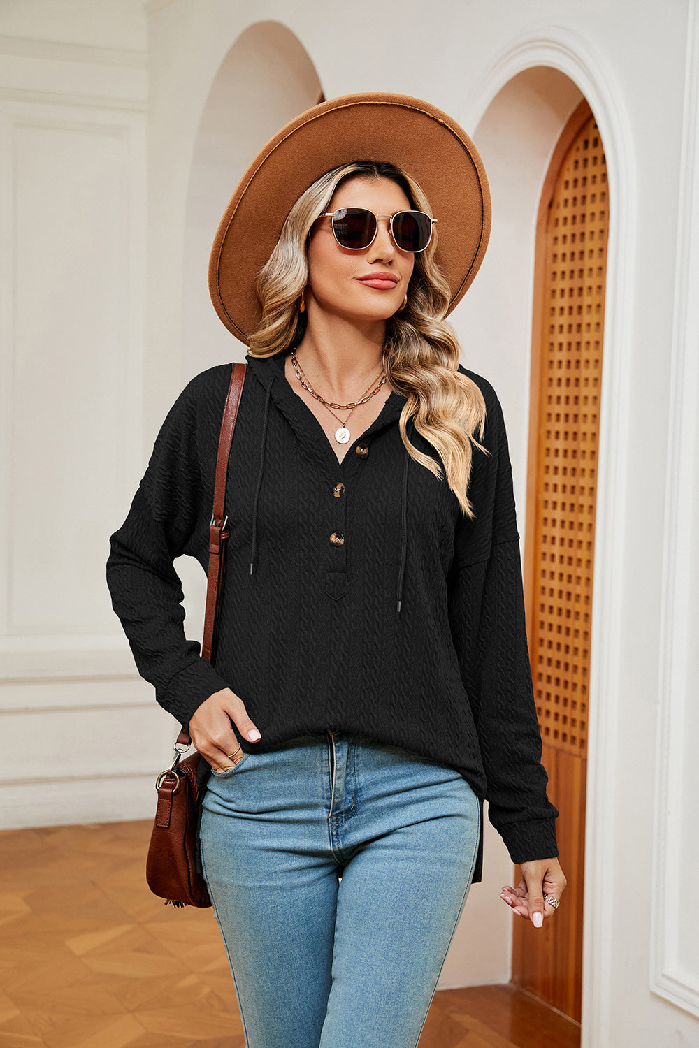 Black textured henley hoodie with drop shoulder, drawstring hood, and button placket.