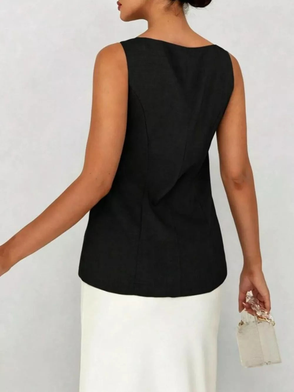 Black sleeveless button-down vest with boat neckline, tailored fit, and a white skirt.