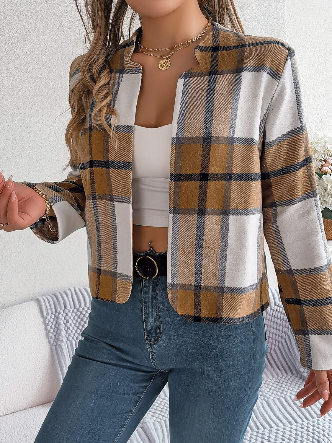 Collarless plaid cropped jacket in camel and white with open front and long sleeves.