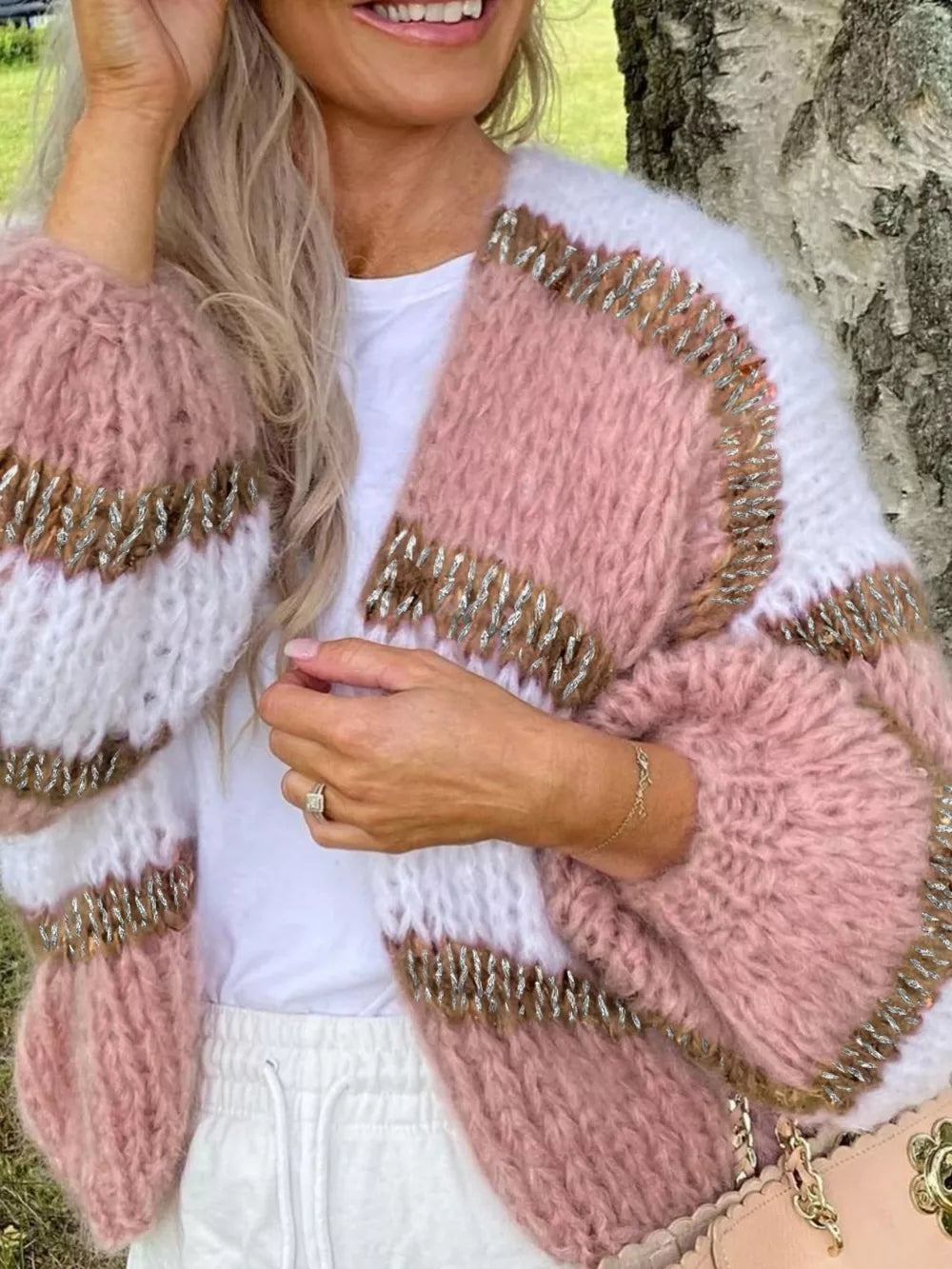 Chic color block open cardigan in pink and white acrylic with balloon sleeves and metallic trim.