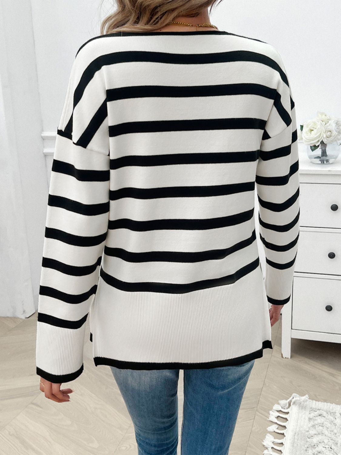 Oversized black and white striped V-neck knit sweater with ribbed hem and cuffs.