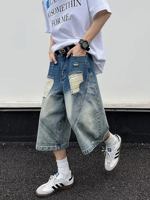 Men's distressed wide-leg denim shorts in light wash blue with ripped details.